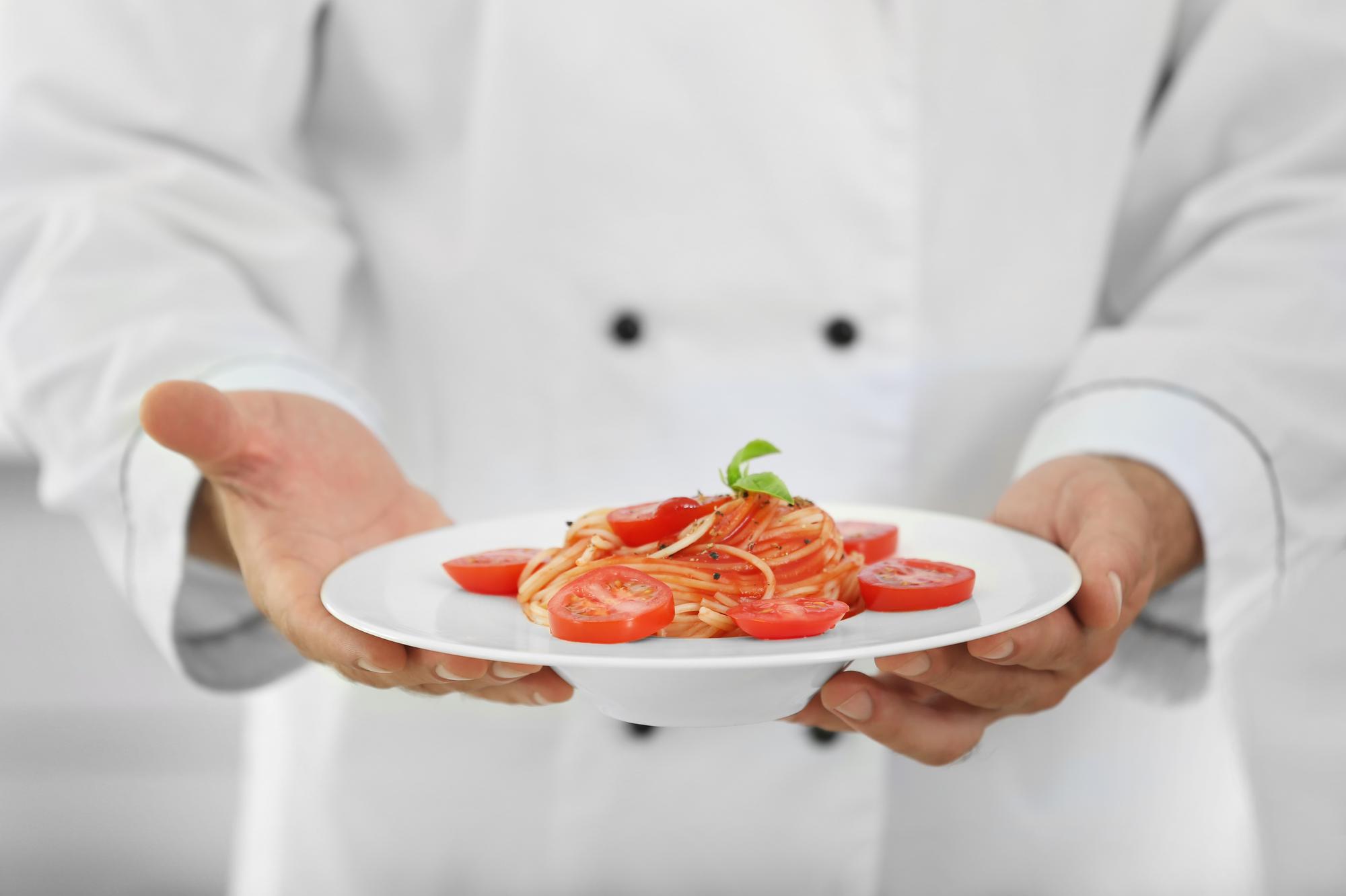 Chef arranging plated dish in artisan kitchen